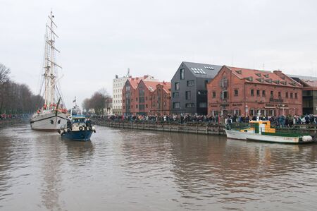 KLAIPEDA, LITHUANIA  NOVEMBER 10: Klaipeda city symbol barquentine "Meridianas"  passes old historical warehouses on her way to the major overhaul  on November 10, 2012 in Klaipeda.のeditorial素材