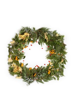 Christmas frame wreath with evergreen fir tree and red and yellow berries isolated on white. Flat lay, top view.の写真素材