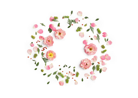 Floral round frame on white background. Flat lay, top view. Ornament with rose flowers, petals, succulent plants, green leaves and red berries with space for text.の写真素材