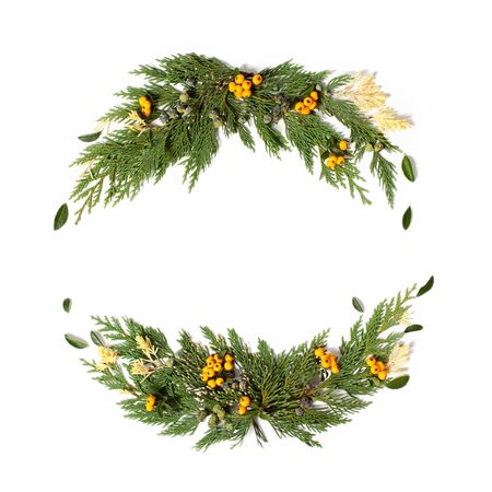 Christmas concept - frame wreath with evergreen Cupressus nootkatensis and Pyracantha red and yellow berries. Flat lay, top view.の写真素材