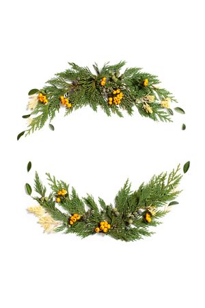 Christmas concept - frame wreath with evergreen Cupressus nootkatensis and Pyracantha red and yellow berries. Flat lay, top view.の写真素材