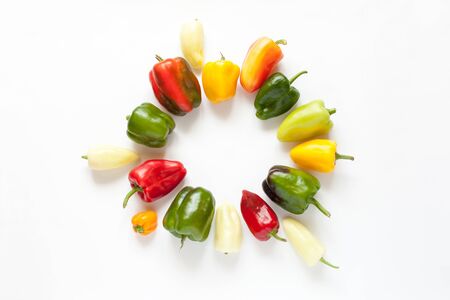 Round frame of vegetables isolated on a white background. Colorful bell peppers circular arrangement. Top view, flat lay.の写真素材