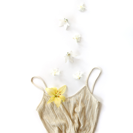 Golden dress and motion flowers on white background. Flat lay, overhead viewの写真素材