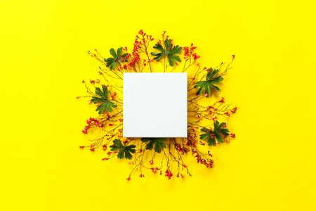 Holiday card mockup, decorated with tiny red flower frame, green leaves with blank space for a text.の写真素材