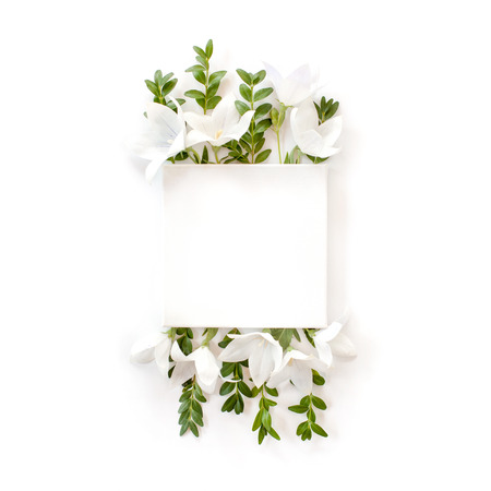 white fabric mock-up with blooming white bell flowers and leaves. flat lay, top view. の写真素材