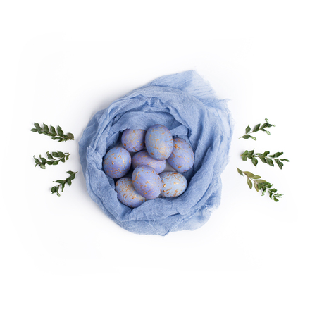 Easter concept. Blue eggs in textile nest with green branches. Flat lay, top view.の写真素材