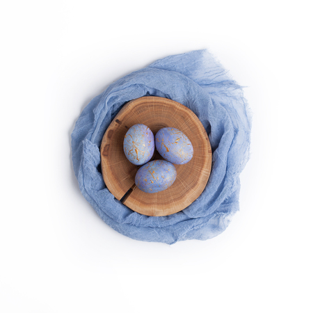 Easter card. Creative nest made of gold and blue speckled easter eggs with pastel colored textile.の写真素材