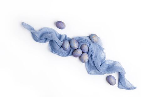 Easter speckled blue eggs on white background with pastel color textile. Flat lay. Top view.の写真素材
