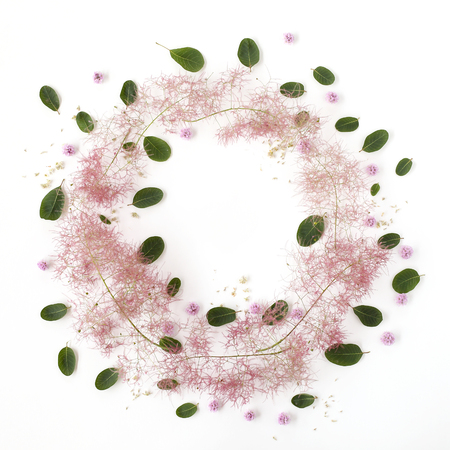 Valentine`s Day floral flat lay frame on white background. Wreath made of pink buds, purple smoke tree buds, seeds and green leaves. の写真素材