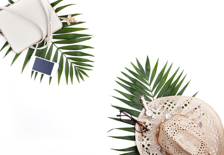 Travel concept, creative arrangement on white background. Palm leaves, handbag, straw hat, mobile phone isolated. Flat lay, top view.の写真素材