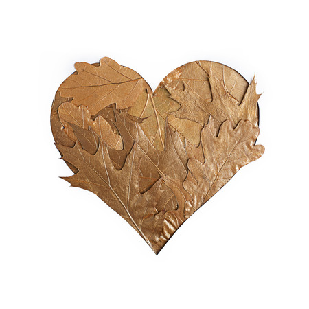 Heart made of golden metallic leaves on white background. Creative Valentine`s day concept. Flat lay.の写真素材