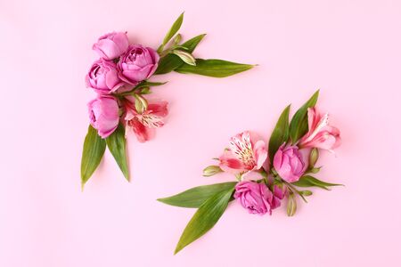 Rose buds frame on pink background. Flat lay, top view floral greetings concept.の写真素材