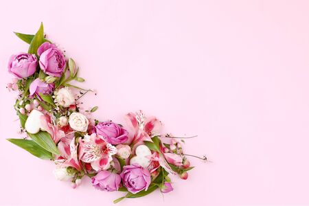 Floral frame made of rose flowers, branches, leaves and heart shaped cookies isolated on pink background. Flat lay, top view. Romantic concept.の写真素材