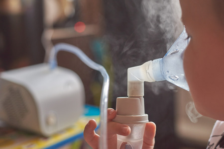 The child at home makes inhalation. Treatment of children at home.の写真素材