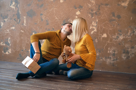 The guy with the girl exchanged gifts and the guy tries to kiss the girl. Retro style hall.の写真素材