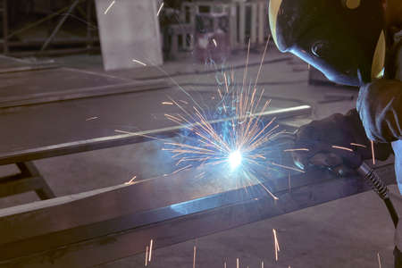 man processes metal with gas electric welding. Welding work on metal.