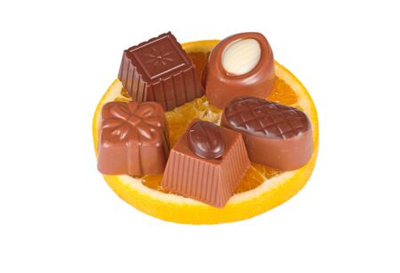Delicious close up of chocolate candy on orange slice, isolated on white backgroundの写真素材