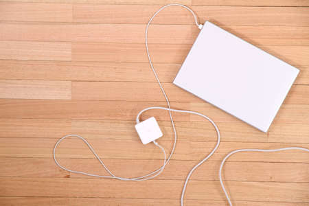 A laptop on a wooden floor の写真素材