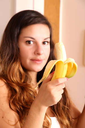 A young woman eating a Banana の写真素材