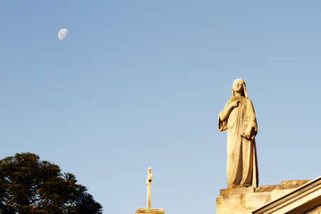 Statue in the Cemetery of Recoleta with the Moon in the background, Buenos Aires, Argentina 