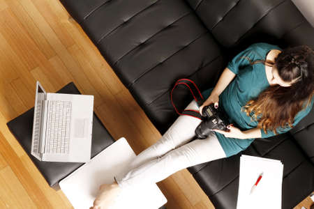 A young latin woman editing images on a digital camera の写真素材