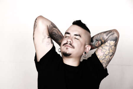 Portrait of a tattooed relaxed, hispanic man 
