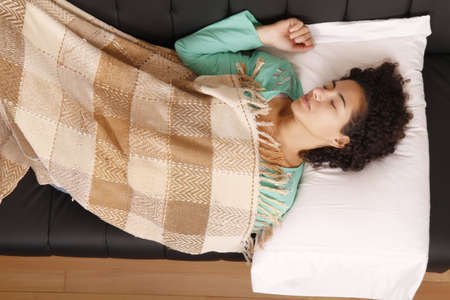 A jung brazilian woman relaxing on the sofa.の写真素材