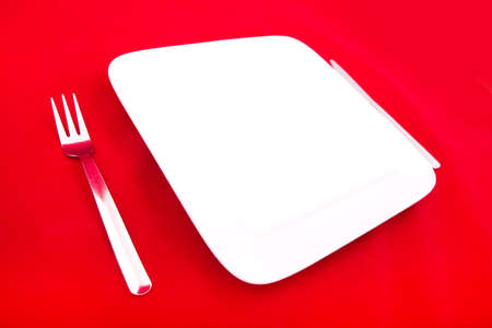 A blank plate isolated on red.の写真素材