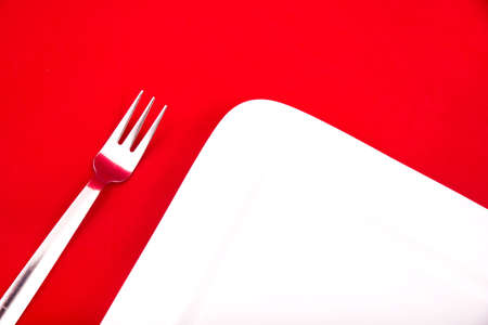 A blank plate isolated on red.の写真素材