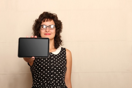 A young woman in a Retro dress holding a Tablet PC.