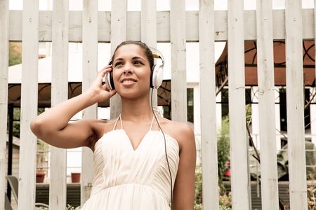 A young hispanic girl enjoying music outdoor の写真素材