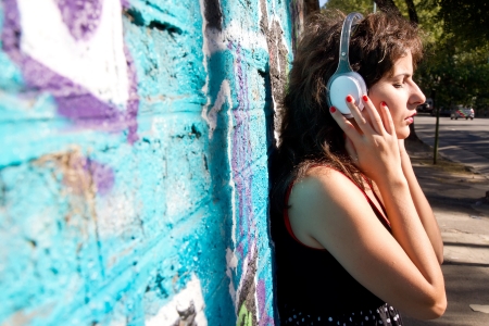 A vintage dressed girl listing to music in a urban environment.の写真素材