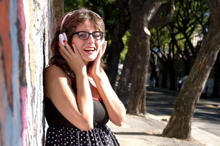 A vintage dressed girl listing to music in a urban environment.の写真素材