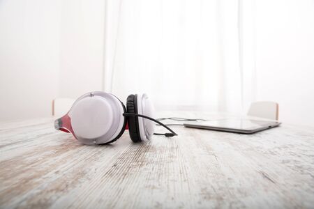 A Tablet PC with headphones on the Table.の写真素材