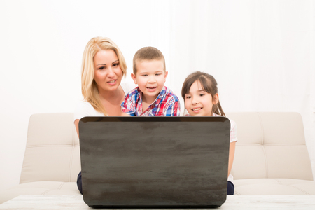 A mother using with her son and daughter a laptop computer.の写真素材