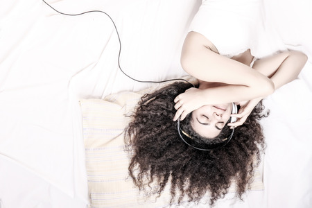 A young latin woman dreaming and sleeping while hugging herself.の写真素材