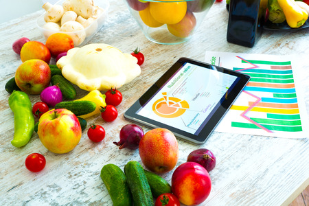 Organic food and a Tablet PC showing information about healthy nutrition and phytochemical composition.の写真素材