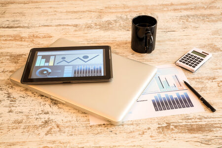 Business Analytics on a wooden Desk with a Tablet PC and a Laptop.の写真素材
