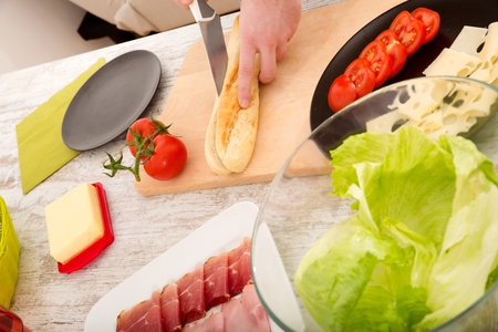 Young man preparing a Sandwichの写真素材