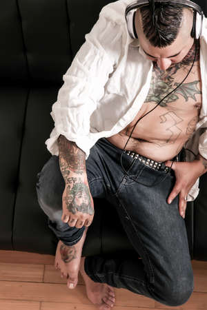Tattooed man on the sofaの写真素材