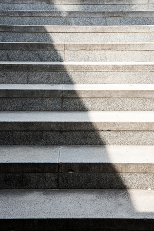 Concrete stairs background with a shadow covering half.の写真素材