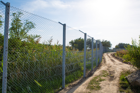 ROESZKE, HUNGARY - SEPTEMBER 15: View on the 175km long fence between Hungary and Serbia installed due to the Refugee crisis on September 15, 2015 in Roeszke, Hungary.のeditorial素材