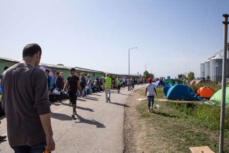 TOVARNIK, CROATIA - SEPTEMBER 19: Stranded Refugees form a waiting line with luggage after their...