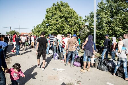 TOVARNIK, CROATIA - SEPTEMBER 18: Stranded Refugees form a waiting line in order to get a transported further towards northern Europe on September 18, 2015 in Tovarnik, Croatia.のeditorial素材