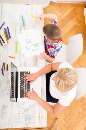 Mother and son with a Laptop at homeの写真素材