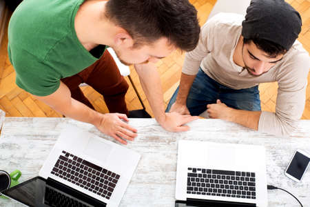 Two young colleagues sharing some ideas in the office