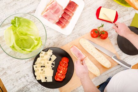 Young man preparing a Sandwichの写真素材