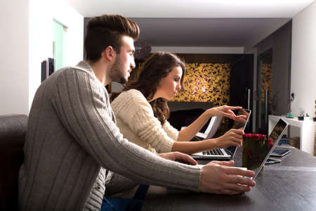 Young couple watching together some content on a laptop computerの写真素材