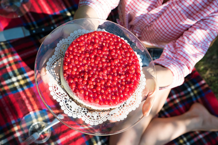 A young woman having a picnic with a cake in the garden.の写真素材