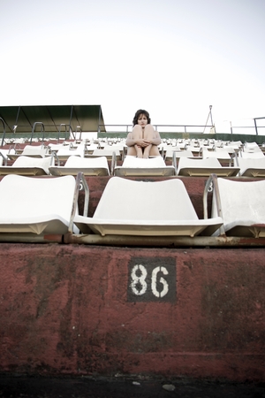 Retro girl sitting in stadiumの写真素材